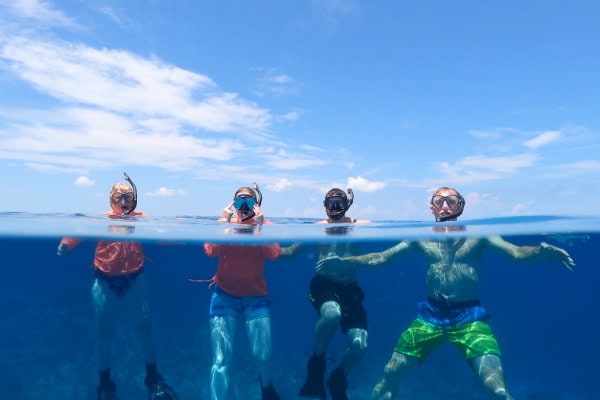 Four men treading water with snorkeling gear