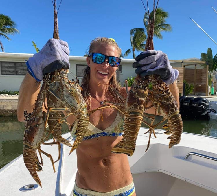 Lobsters being held up by a woman