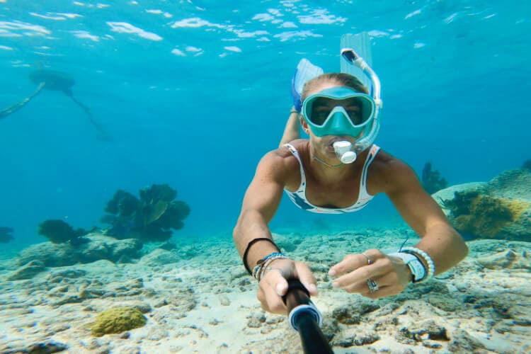 Photo of Jennifer Parramore snorkeling underwater in the Florida Keys. She is using a gopro to take a selfie.